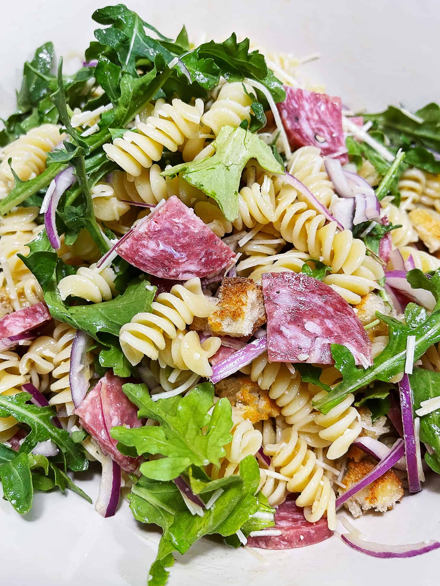 Pasta salad with salami in a bowl.