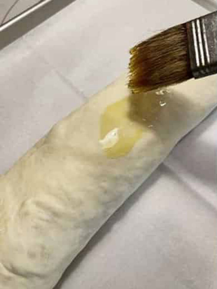 Brushing the dough with an egg wash.