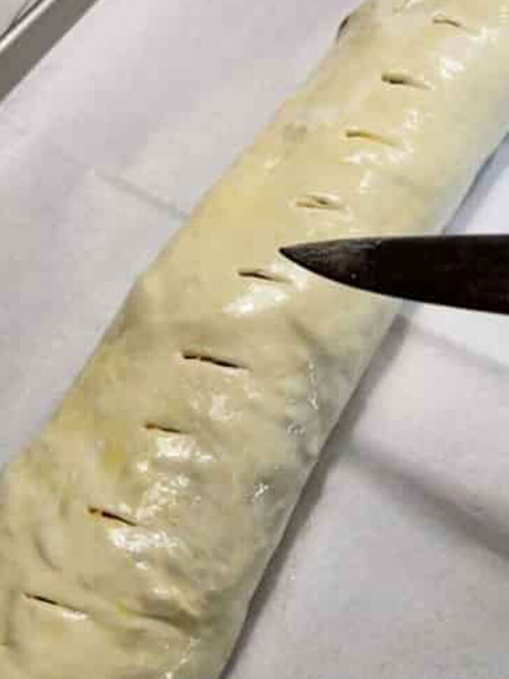 Cutting small slits in the top of the stromboli.