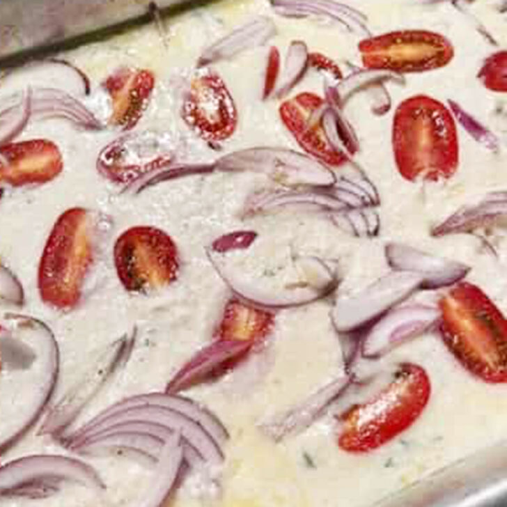 Tomato and onion mixture added to the top of the Dutch baby batter.