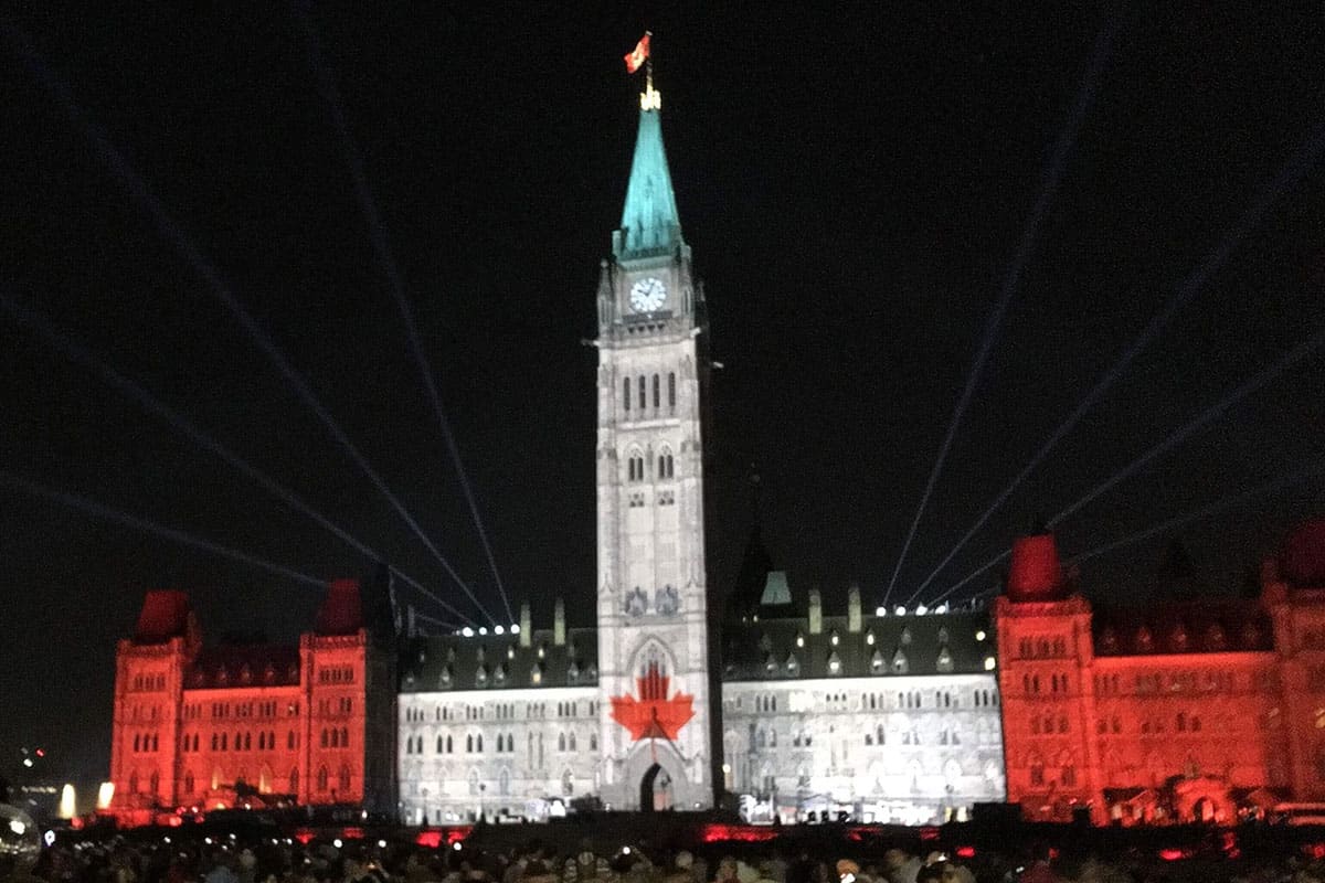 Canadian parliament building lit up in red and white