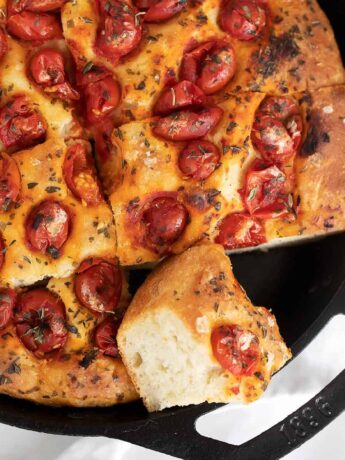 skillet focaccia sliced in cast iron skillet