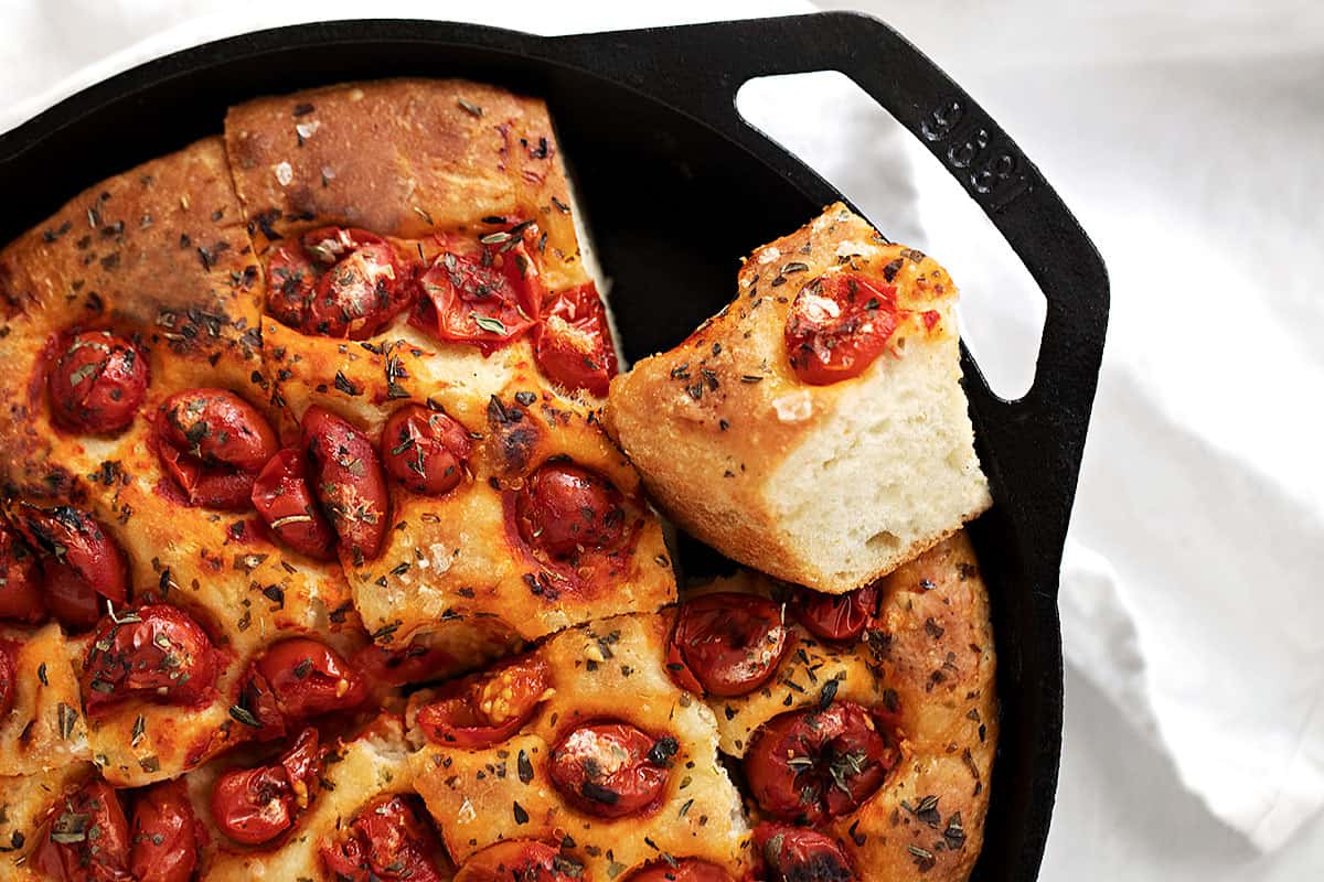 skillet focaccia sliced in cast iron skillet