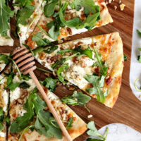 goat cheese white pizza sliced on pizza peel