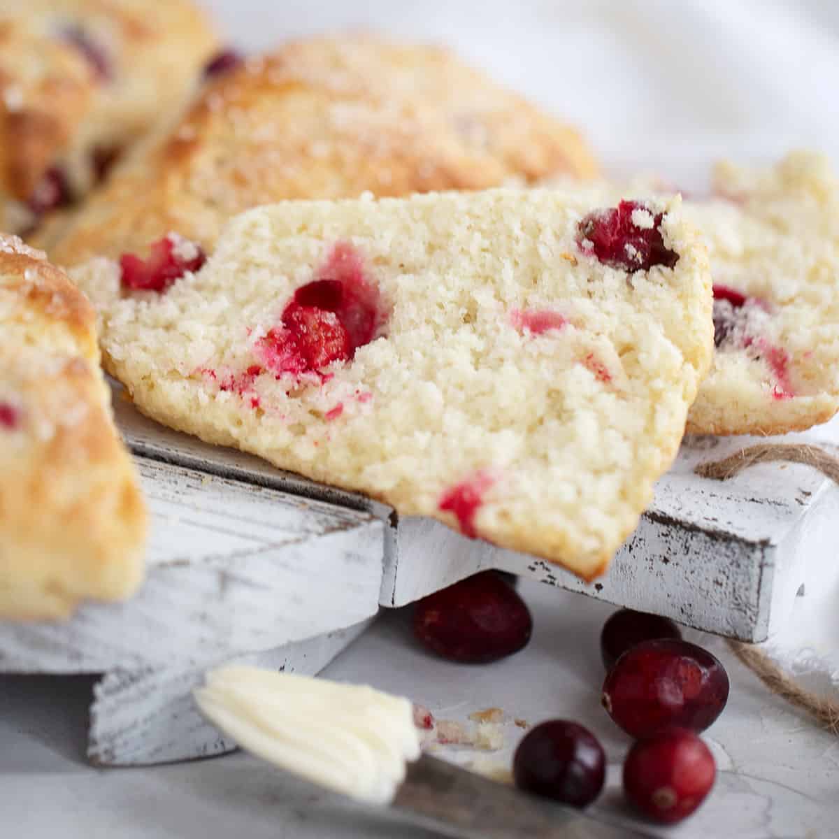 cranberry scones sliced open with a knife and butter