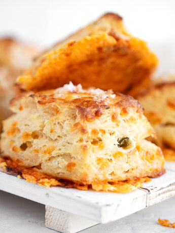 Jalapeño cheddar biscuits stacked on a serving platter.
