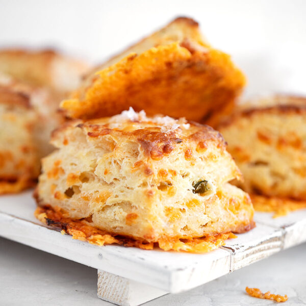 Jalapeño cheddar biscuits stacked on a serving platter.