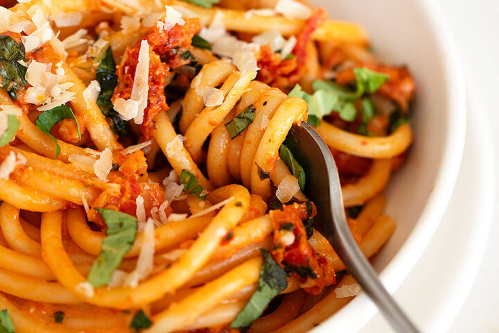 sun-dried tomato pasta in bowl with fork