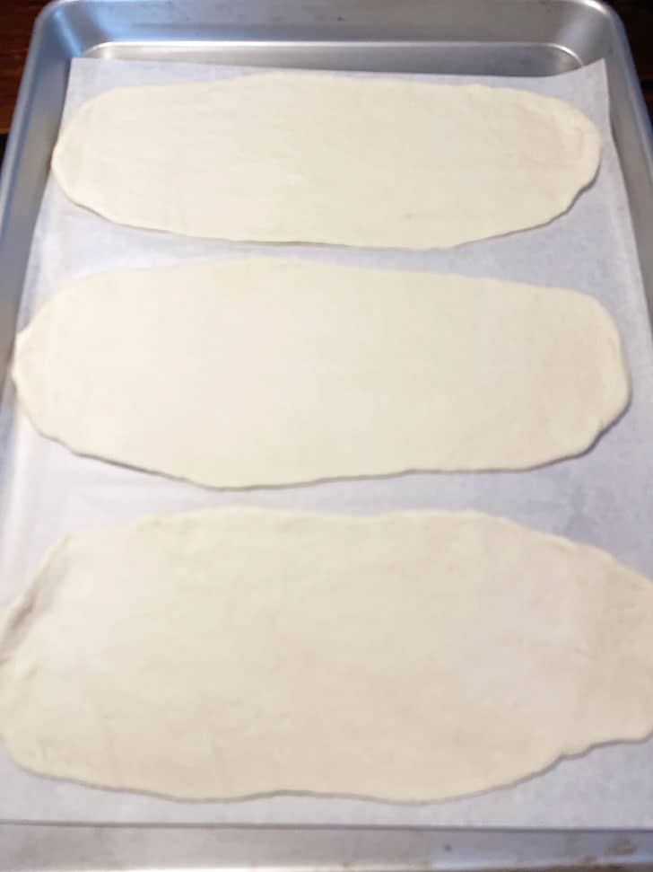 rolled flatbread placed on parchment lined baking sheet
