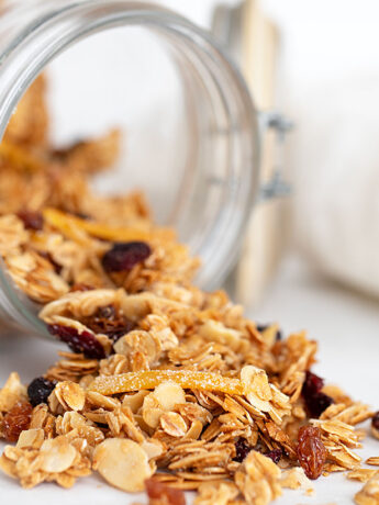 cranberry orange granola spilling out of jar