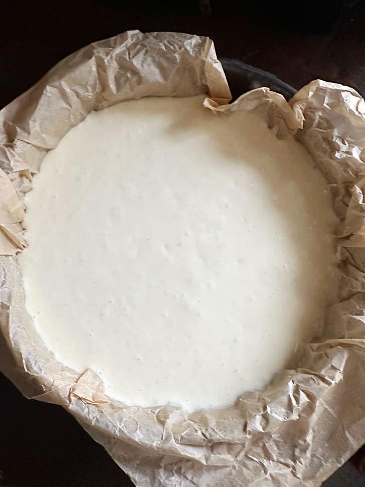 cheesecake batter in parchment lined springform pan