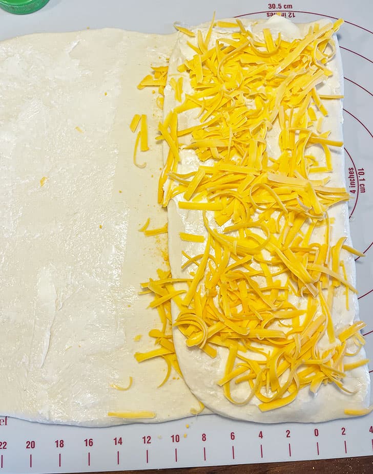 adding more cheese on dough