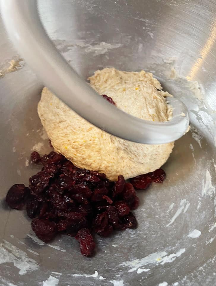 adding cranberries to dough