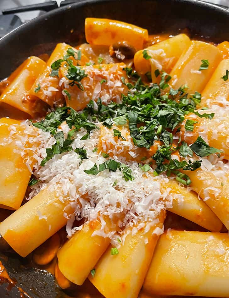 adding basil and Parmesan to pan