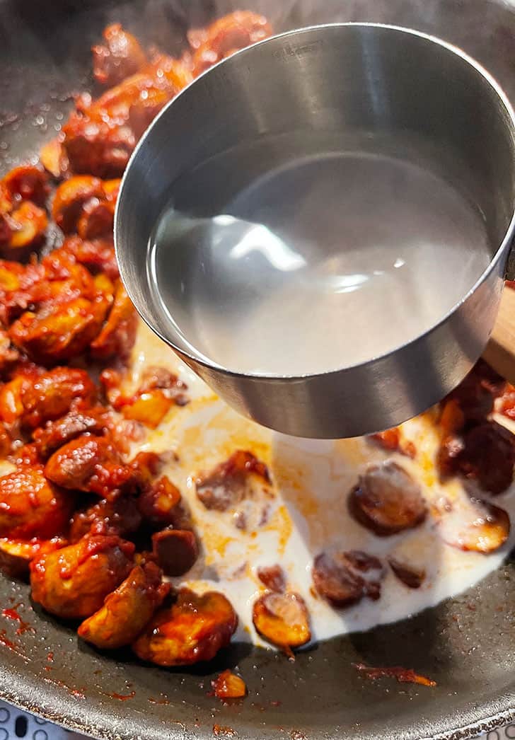 adding pasta cooking water to pan