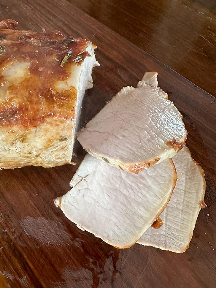 thinly slicing pork loin after resting.