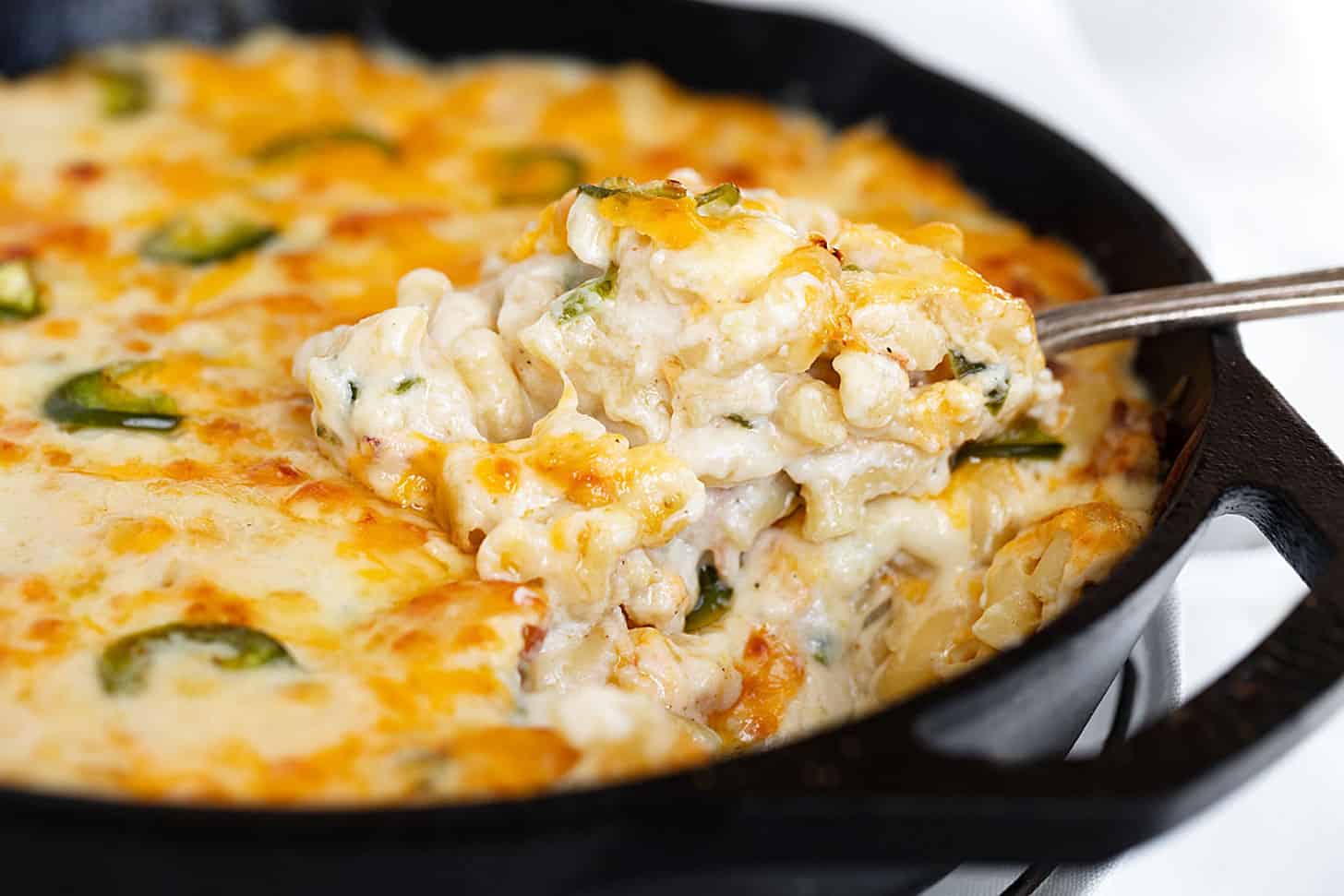 jalapeño mac and cheese in cast iron skillet with spoon