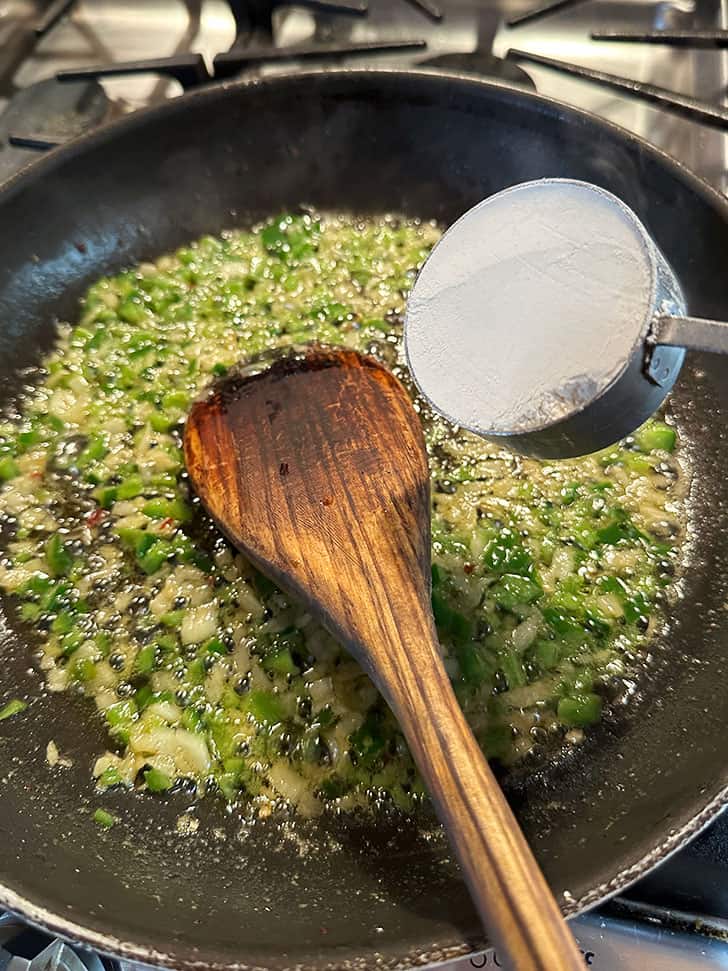 adding flour to sauteed jalapenos and onion