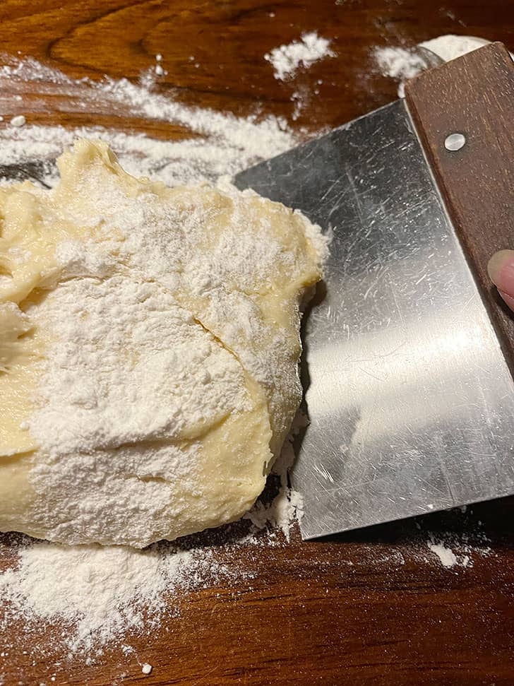 kneading dough with extra flour on the work surface