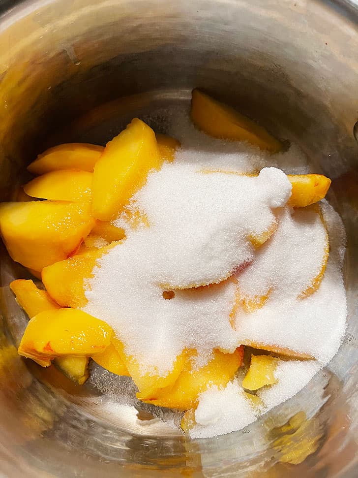 peaches and sugar in saucepan