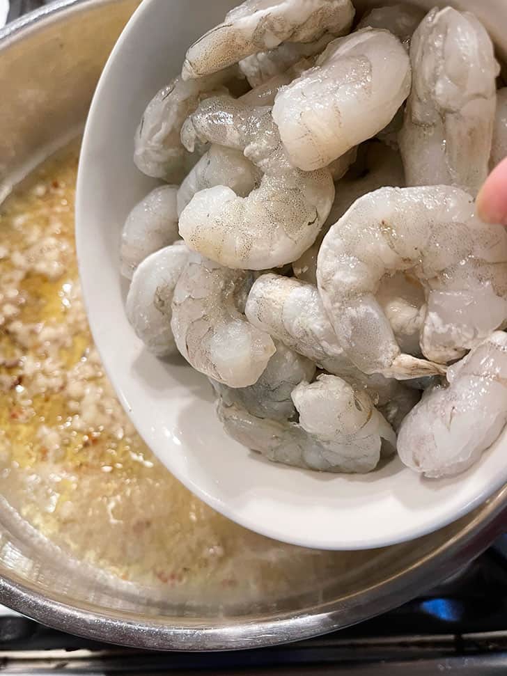adding frozen shrimp to pan