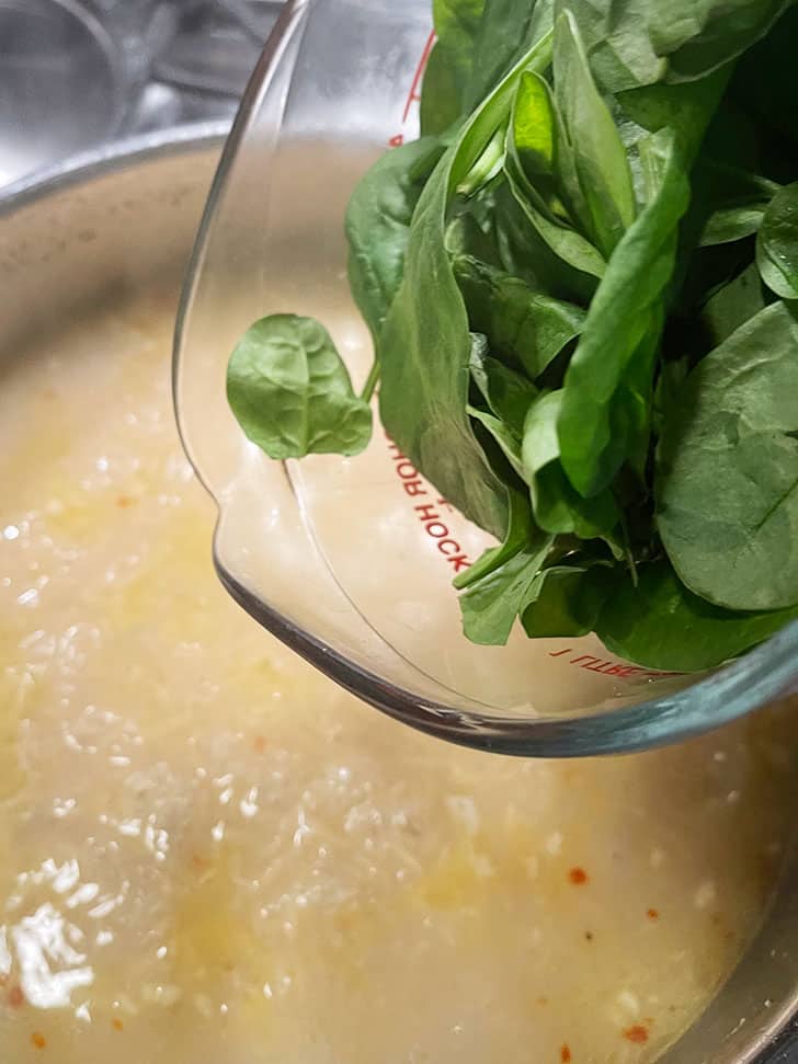 adding spinach to pan