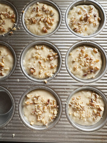 muffins with walnuts on top and ready for oven.