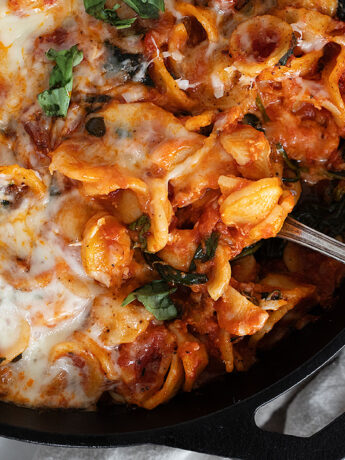 cheesy orecchietta in cast iron skillet with spoon