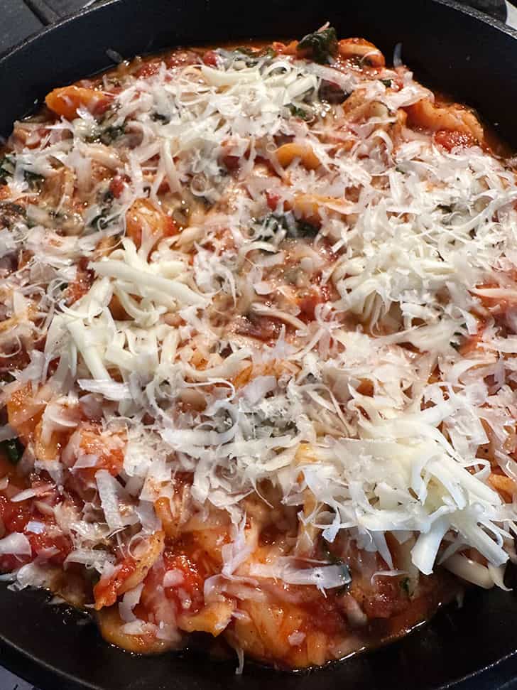 skillet topped with cheese and ready to bake.