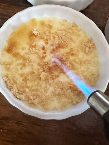 torching sugar topping on creme bruleee