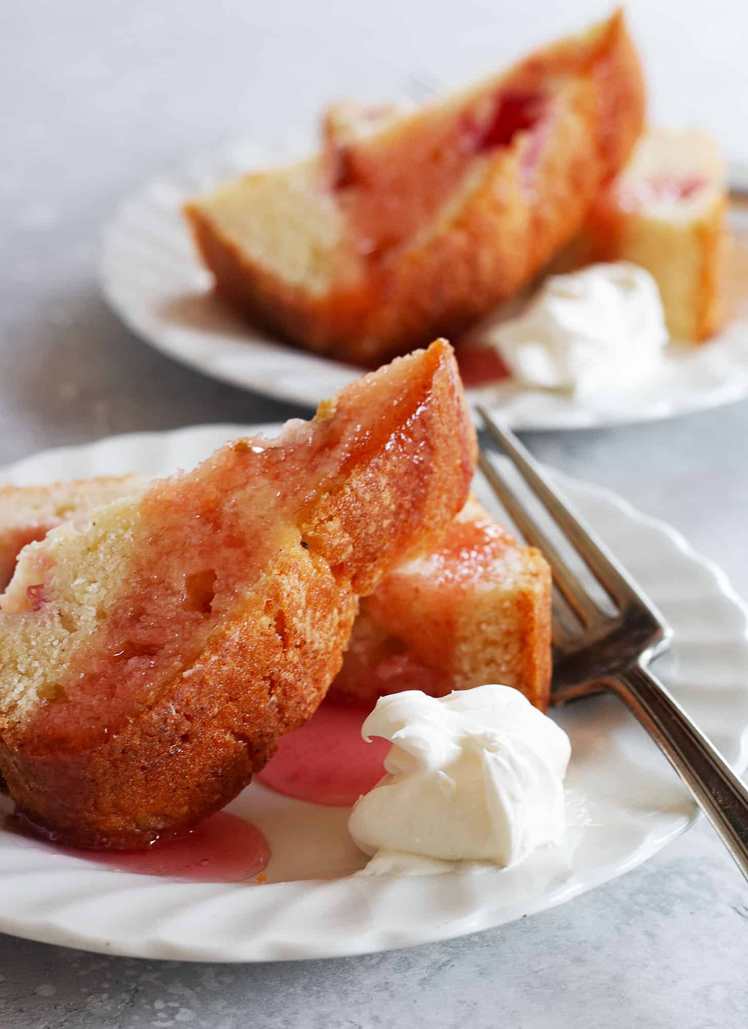 rhubarb loaf cake on plate with fork and whipped cream