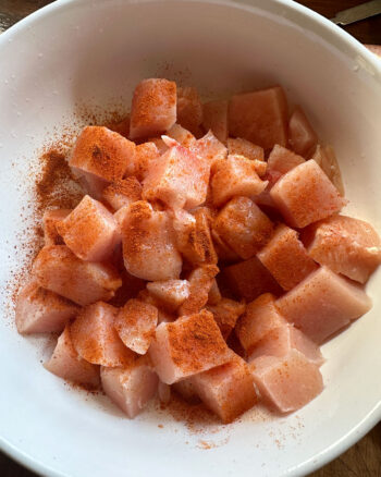cubed chicken marinating in small bowl