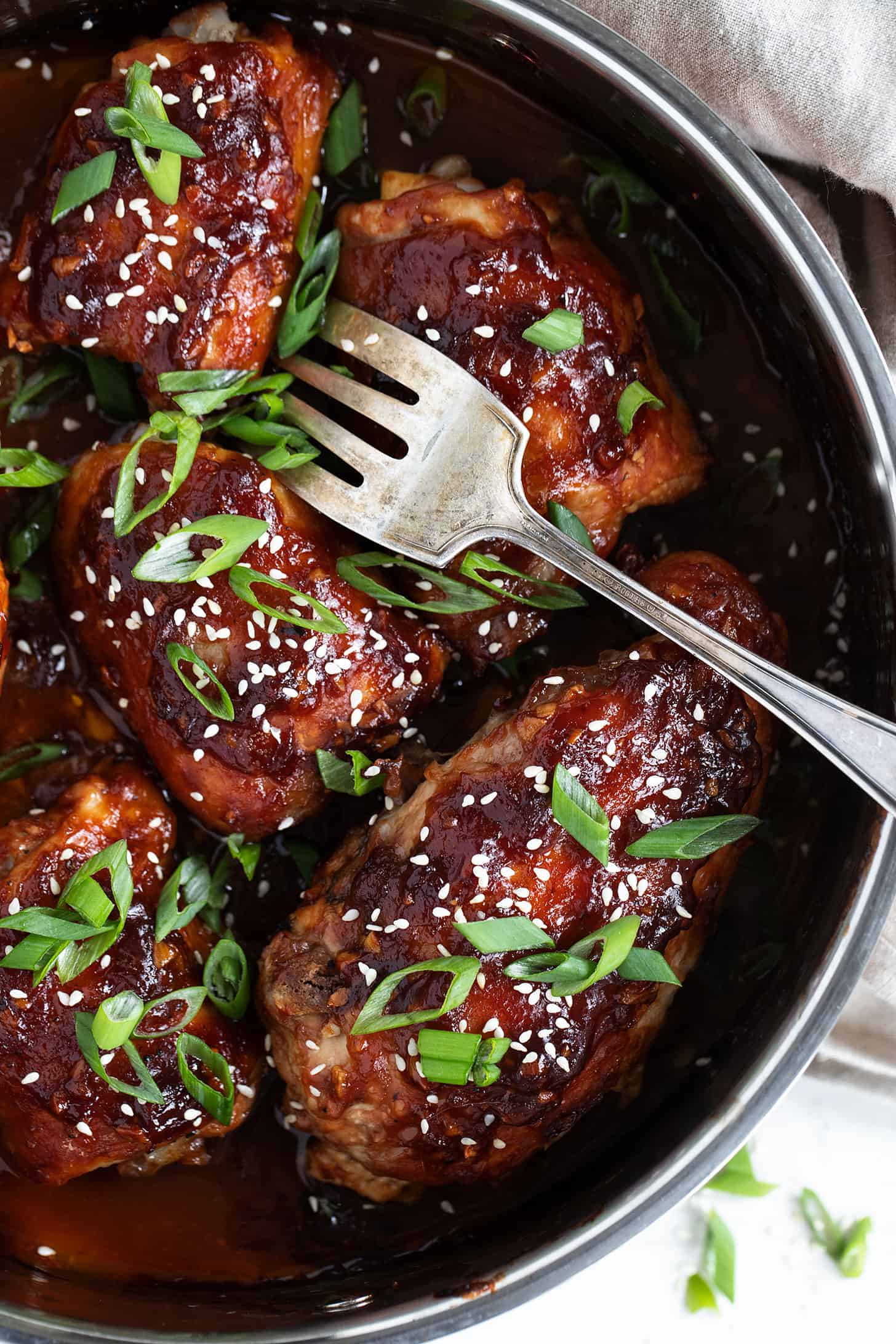 sticky chicken in baking dish with fork