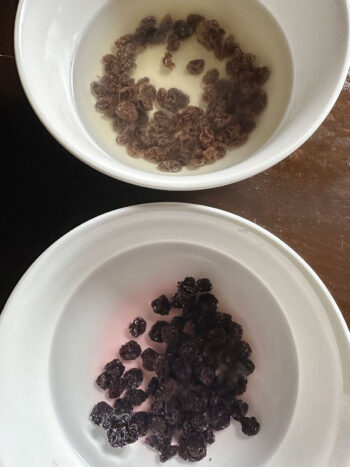 plumping dried blueberries and raisins in hot water in bowls