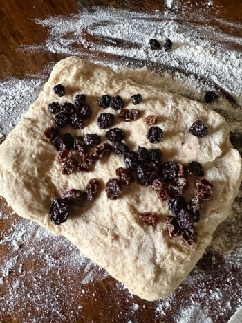 adding dried blueberries and raisins to dough