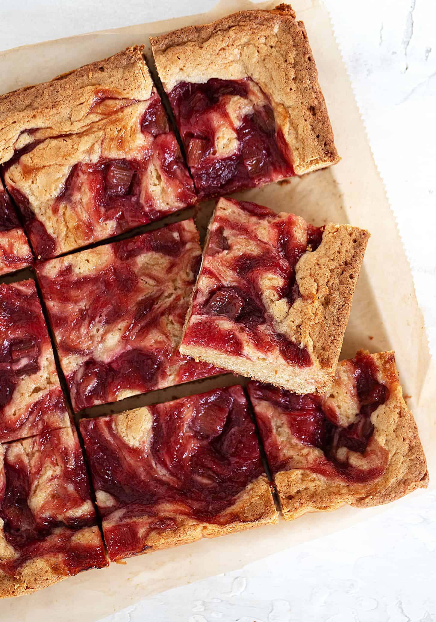 rhubarb blondies cut on parchment paper