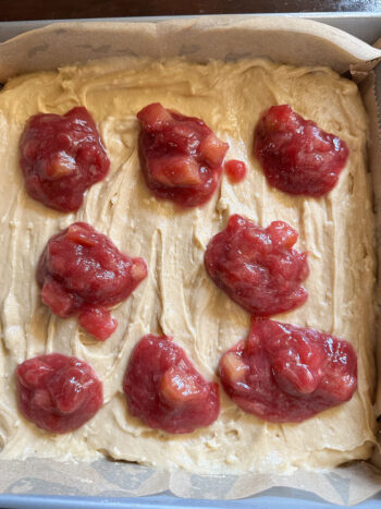 spooning dollops of rhubarb compote on top of batter