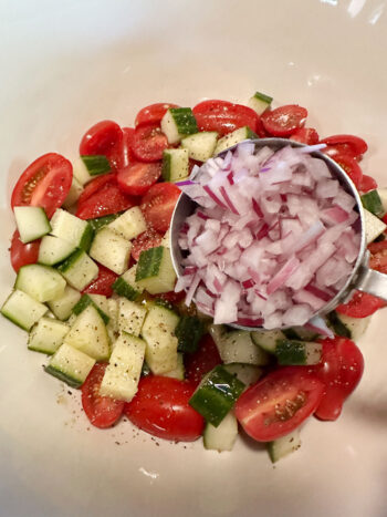 adding onion to  tomatoes and cucumber