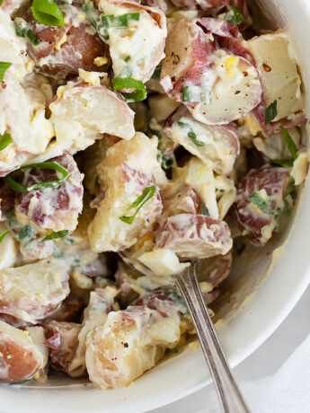simple potato egg salad in white bowl with spoon