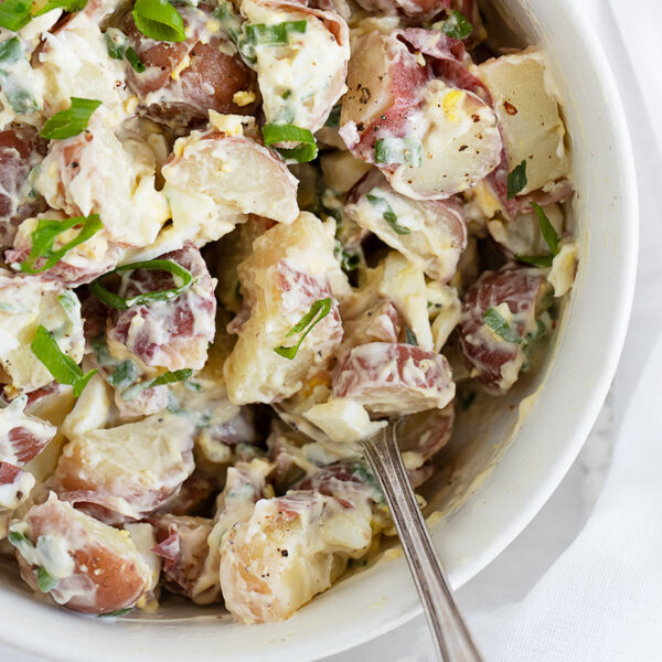 simple potato egg salad in white bowl with spoon