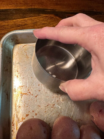 smashing potatoes with measuring cup