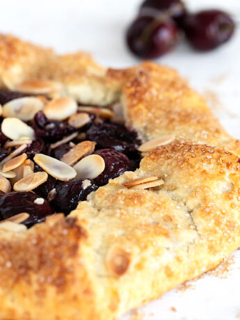 cherry galette with fresh cherries in the background