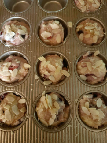 batter in muffin tins topped with almonds