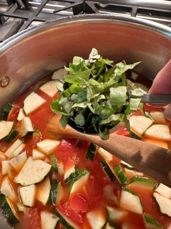 adding fresh basil to soup