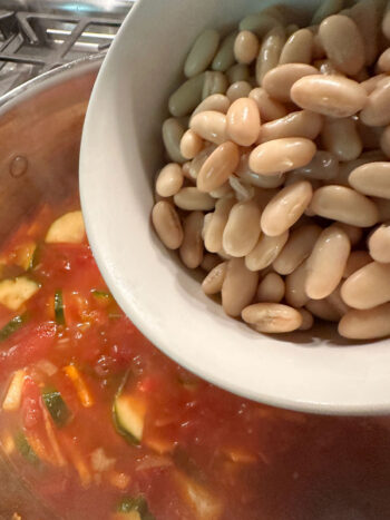 adding cannellini beans to pot