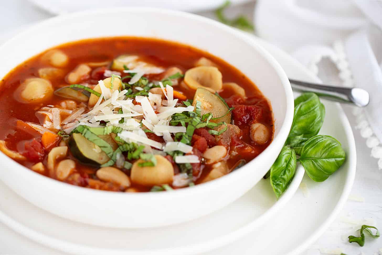 Summer minestrone soup in bowl with basil