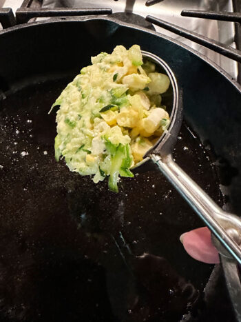 using a scoop to add batter to skillet