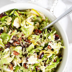 Brussels sprouts and pear salad in bowl with spoon