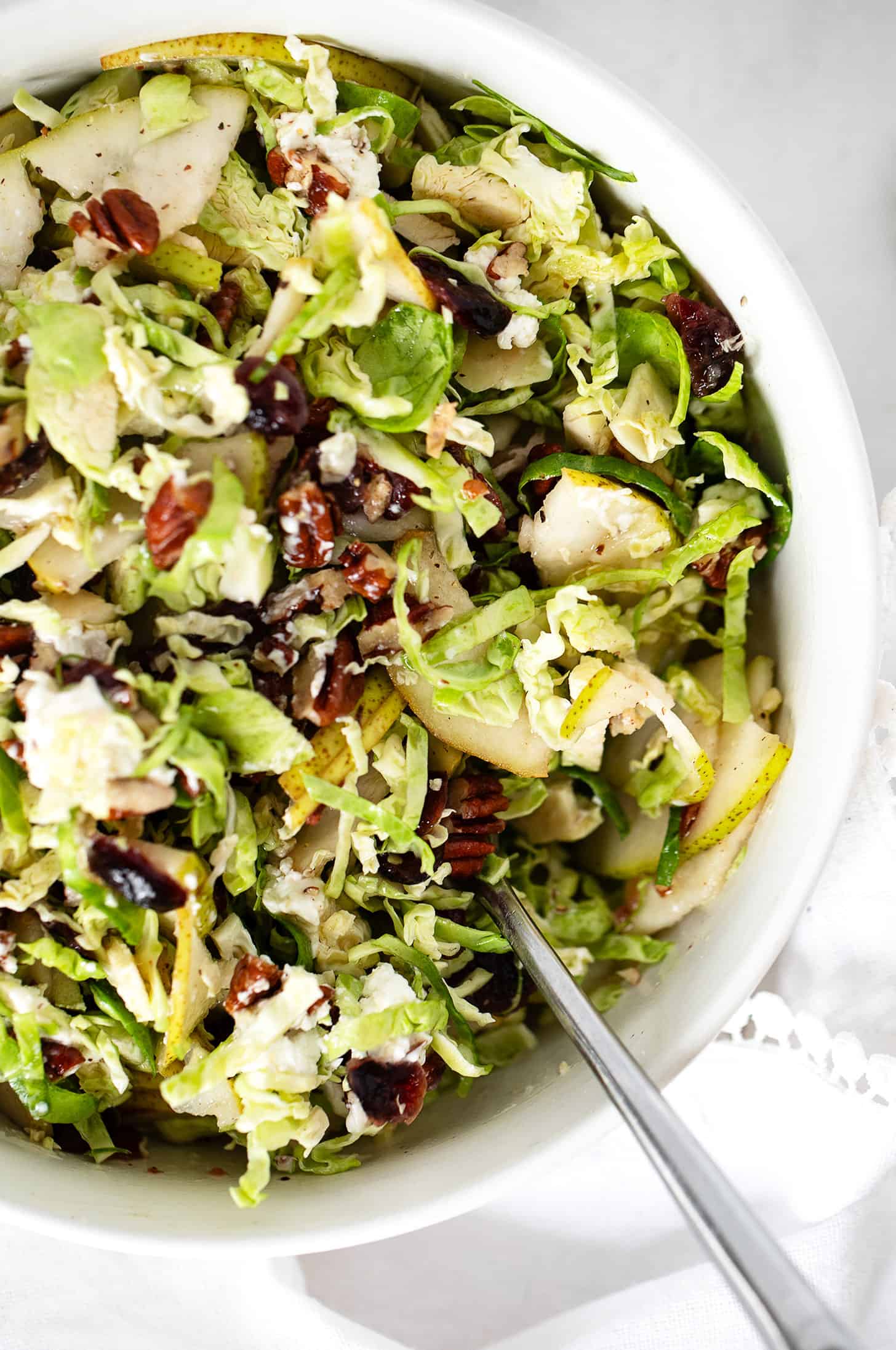 Brussels sprouts and pear salad in bowl with spoon