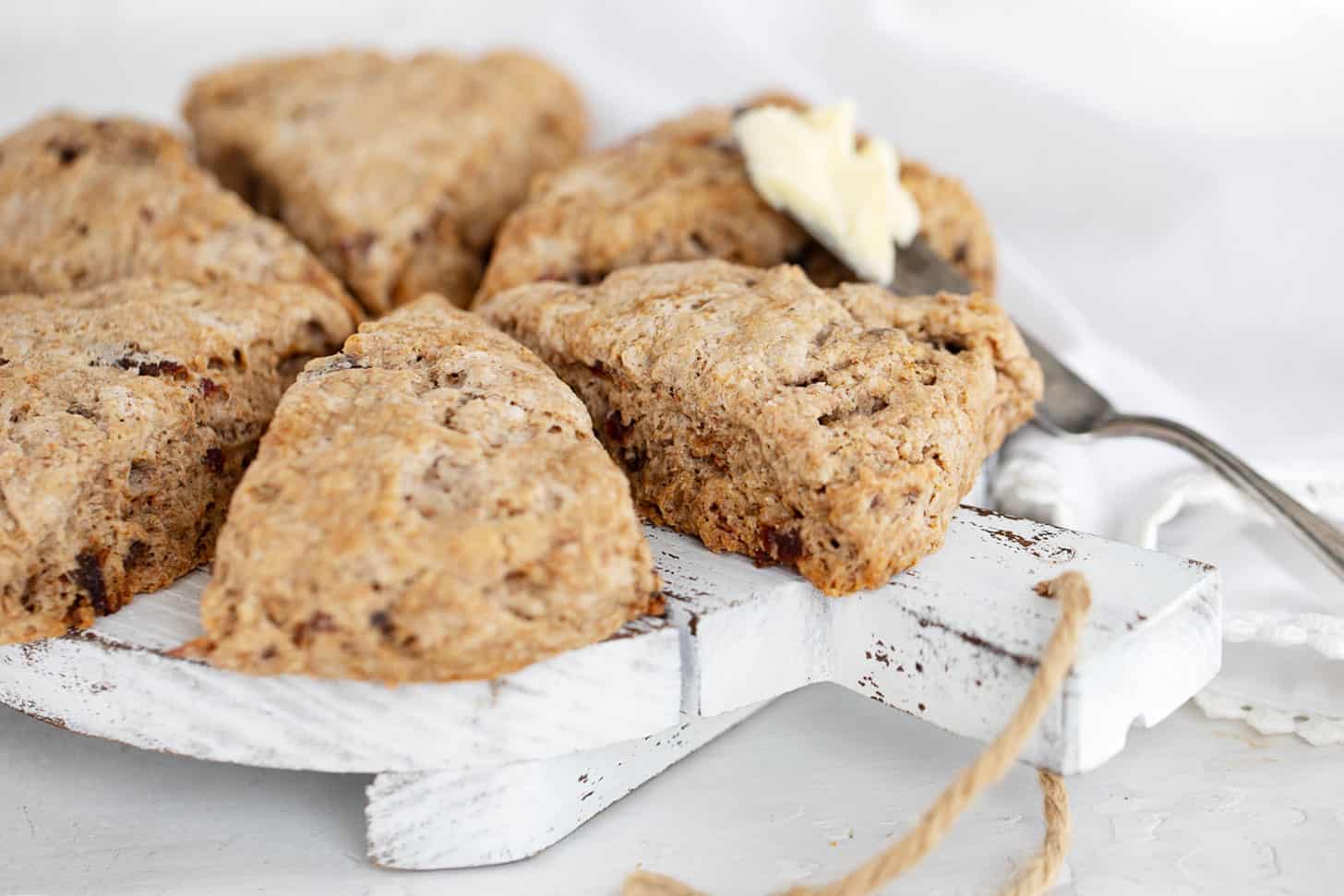 date scones on serving board with knife and butter